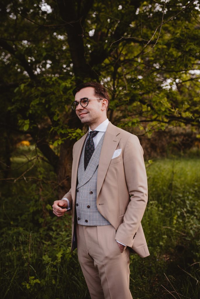 Beżowy garnitur na ślub, kamizelka w kratę, szara, stylistyka boho, zdjęcia w plenerze.